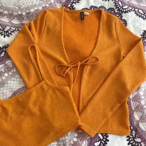 Very bright orange noce crop top vest and a cardigan. Super cute on