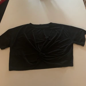 Tröja med knut  - En svart lite kortare tröja med knut. Fint skick och köparen står för frakten.