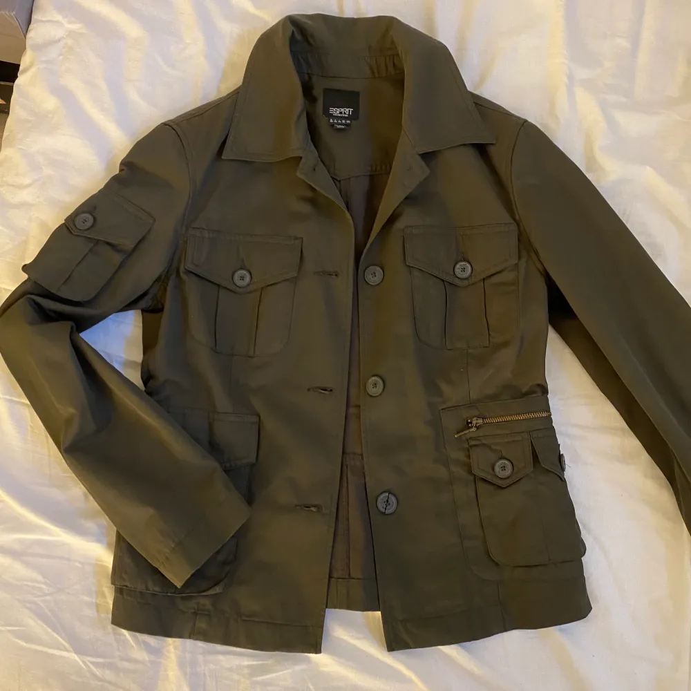 En tunn militärgrön jacka från Esprit. Perfekt höstjacka med många fickor. Köpt på sellpy och sedan tvättad, aldrig använd efter det då den är för liten! . Jackor.