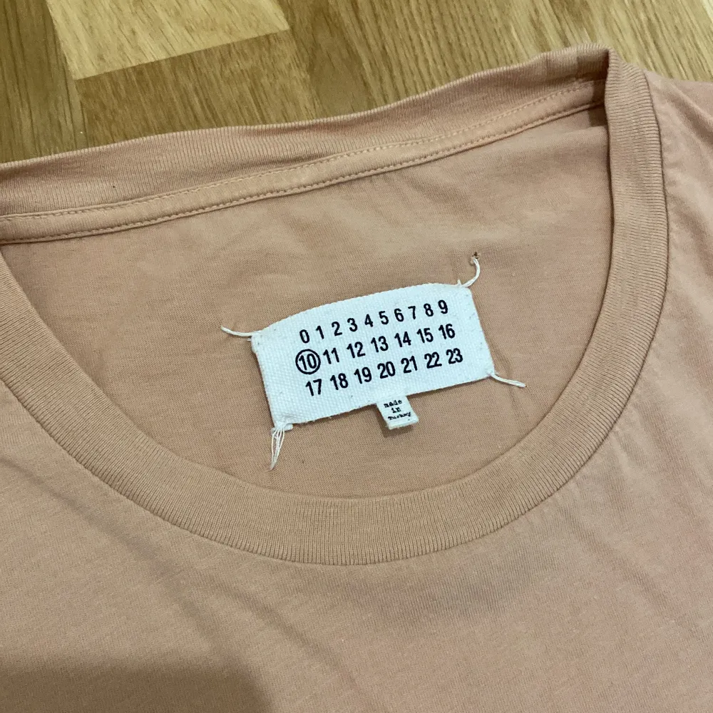En pastell rosa t-shirt från Maison Margielas men’s collection. Tröjan är rare och i bra kvick. Äkta. Storlek 48 italien (storlek M). Sitter true to size. Funkar både på tjejer och killar. T-shirts.