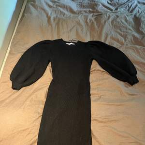 En svart stickad klänning från Zara. Den lägger sig längst kroppens former men är inte för tajt! Den har oxå fina balong ärmar! 