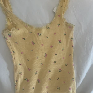 Ljusgult linne - Ljusgul topp med blommor och spetskant 