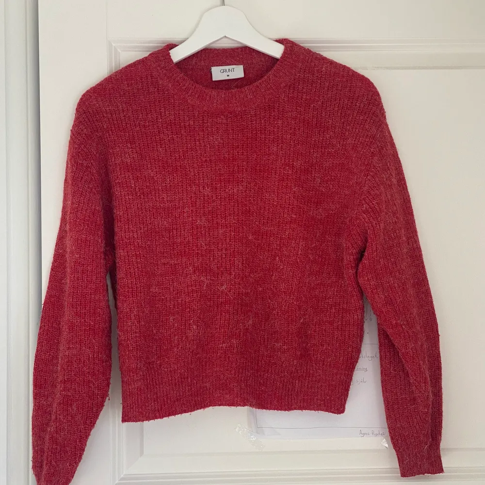 Jag säljer denna röda stickade tröja i storlek M från märket GRUNT. Skulle säga att den sitter som en S, använd ett fåtal gånger🥰. Tröjor & Koftor.