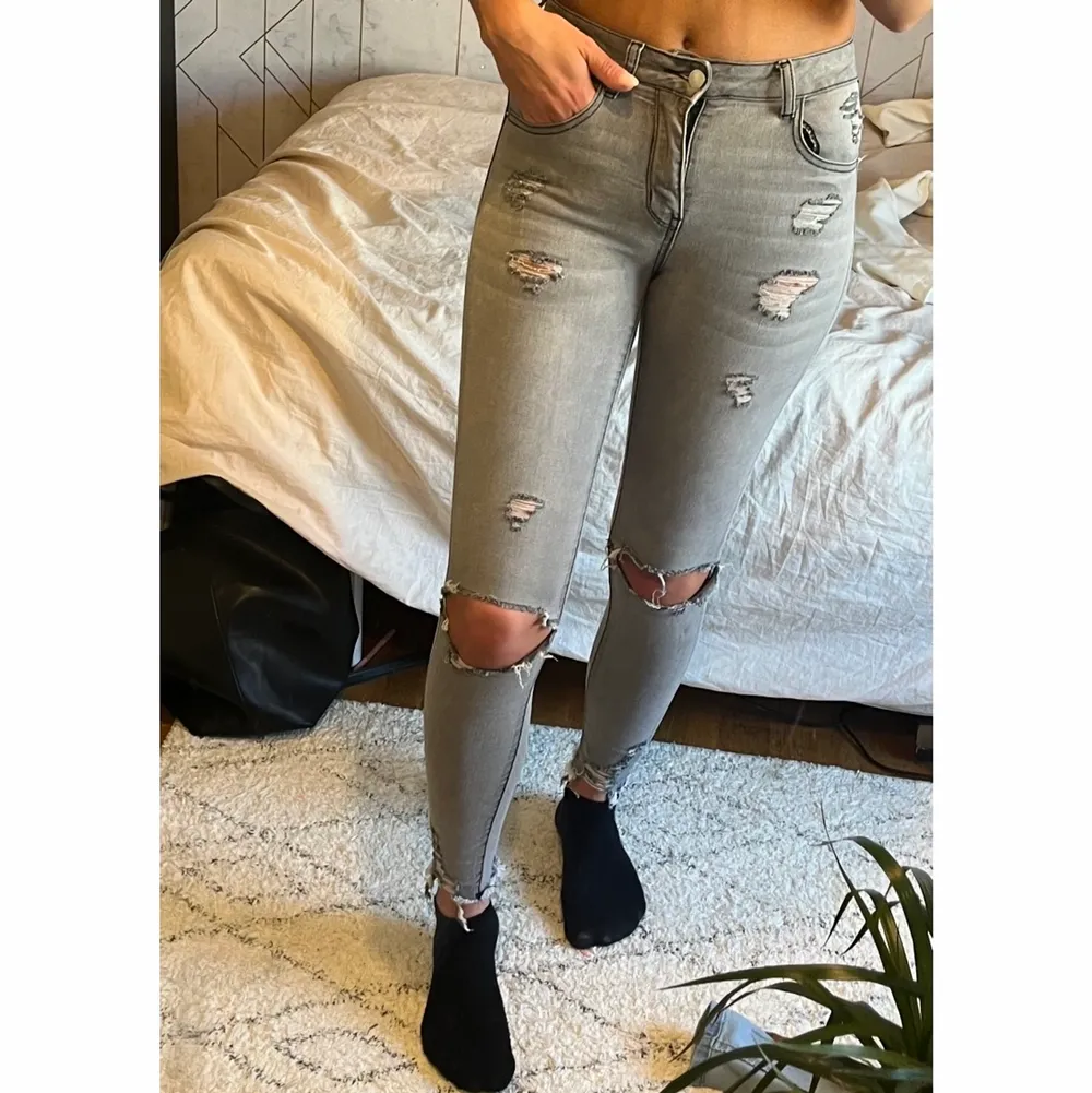 Grå slitna jeans . Jeans & Byxor.