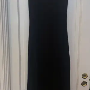 Oanvänd svart klänning 