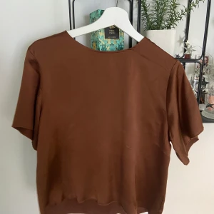 Brun silkejtröja - Silkesliknande tyg, mindre missfärgning på ryggen (syns på sista bilden) men använd ytterst få gånger. 