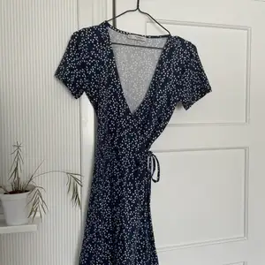Mörkblå blommig klänning från Pull&Bear Använd 1 gång  Köparen står för eventuell fraktkostnad 