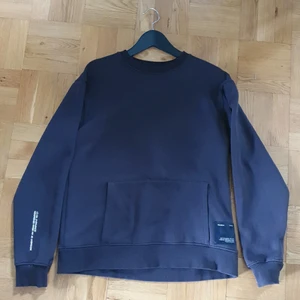 Stilren tröja med snygga detaljer - Collegetröja som använts väldigt sparsamt. Detaljer som magficka och armtext gör att tröjan sticker ut från mängden i all sin enkelhet.