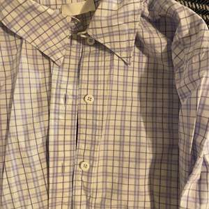 En boxig skjorta i rutigt mönster från HM. Fin lila/blå färg och snygg modell. 