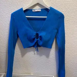 Croppad stickad tröja från Zara i jättegin blå färg med knytdetalj framtill som kan anpassas! Endast använd en gång så i superfint skick☺️