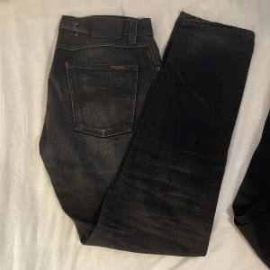 Nudie jeans - ett par nudie jeans i modell steady eddie i storlek W31 L32 i män storlek. grå-svart färg. knapp gylf. använt sparsamt. har snusdose ring på backfickan. 