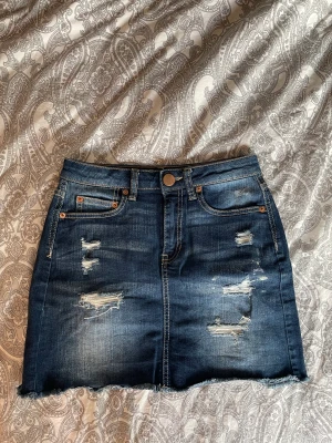 Jeanskjol med slitningar  - Mörkblå jeanskjol i fint skick. Stretchigt material, passar XS och S 💛