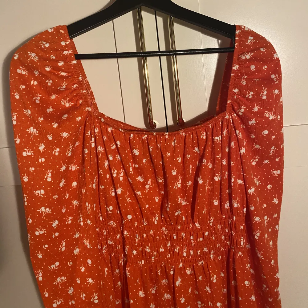 Långärmad röd/orange somrig klänning från H&M, använd en gång, nypris 249kr. Går att ha både off shoulder och med lite piffigare axlar. Frakt tillkommer!!!. Klänningar.