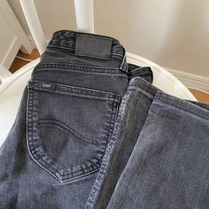 Mörk gråa lee jeans som inte kommit till användning. De är lågmidjade men har ett litet hål på knät där av priset. 