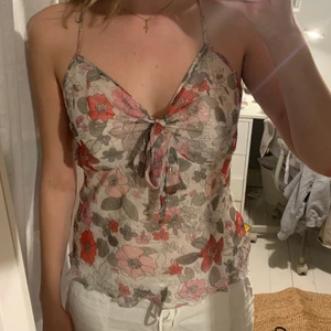 Blommigt linne - Bekvämt sommar linne med lite glitter sömmar och knyte i mitten❤️ använd några gånger men är i fint skick!