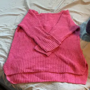 En rosa stickad tröja med en längre baksida och en dragkedja där bak. Aldrig använt! 