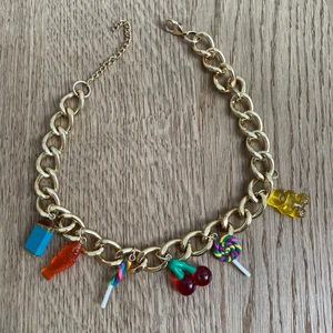 Halsband med godis medaljonger på  - Halsband med guldkedjor och godis medaljonger på. Lite använd och en medaljong fattas brevis gummibjörnen. Köpte den på Dylan’s candy bar.