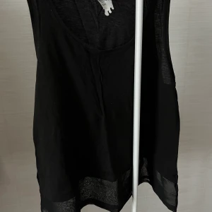 Svart topp - Svart linne med genomskinligt där nere. Köpt på Monki ett par år sen men använd fåtal gånger.