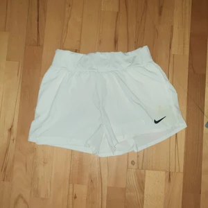 Vita NIKE shorts / badshorts. Slimfit - Vita NIKE shorts / badshorts. Obs finns en liten fläck precis ovanför nike märket som säkert går bort i tvätten, men syns knappt.  Darav det låga priset.