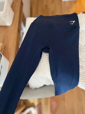 Mörkblå träningsbyxor från Gymshark - Mörkblå träningsbyxor från Gymshark i storlek S med normal midja och stretchigt mjukt material. Tight passform och raka ben. Aldrig använda. 100 kr!