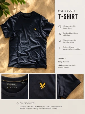Marinblå t-shirt från Lyle & Scott - Snygg marinblå t-shirt från Lyle & Scott med broderad gul örn på bröstet. Tillverkad i mjuk och behaglig bomull med klassisk passform och rund hals. Perfekt för en stilren och enkel look.