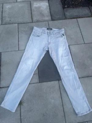 Ljusblå raka jeans - Säljer ett par ljusblå jeans med rak passform och klassisk femficksdesign. Jeansen har en enkel look med subtila sömmar och är tillverkade i denim. Perfekta för dig som gillar en clean och avslappnad stil.