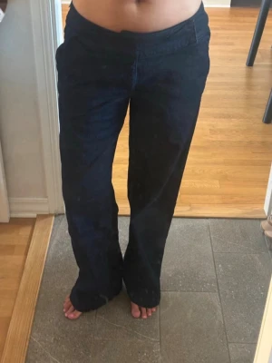 Mörkblå jeans - Säljer ett par mörkblå jeans med raka ben. Jeansen är låg/midwaist beroende på vart man vill ha dom. Perfekta för dig som gillar en avslappnad och trendig stil.