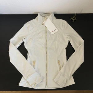 Lululemon Define Jacket Luon – Vit – Strl 2 - Vit Lululemon Define Jacket Luon i storlek 2.  Oanvänd. Etiketter sitter kvar. Inga skador eller slitage. Se bilder för skick och detaljer.                                               Skickas snabbt och packas väl. Hör gärna av dig om du har frågor eller vill ha fler bilder.