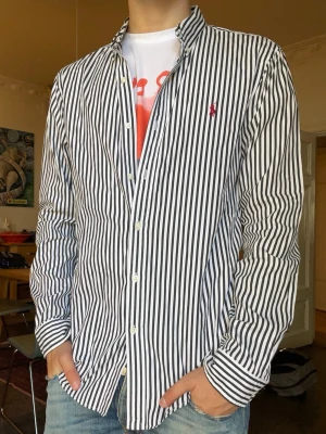 Randig polo Ralph lauren skjorta  - Polo Ralph lauren skjorta. Inga defekter. Modellen är 180cm 65kg och bär storlek m.  Fråga gärna frågor! (Kan gå ner mer i pris vid köp av bundles🤩)