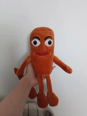 Lv - Rolig brun mjukisleksak i plysch med broderat ansikte, stora ögon och röda läppar. Leksaken har långa armar och ben och är mjuk och kramvänlig. Perfekt som present eller dekoration.