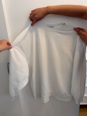 Vit tröja - Stilren vit hoodie utan luva. Perfekt storlek och perfekt fin vit färg. Modellen sitter ordentligt och fint. 