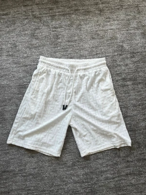 Vita Fendi shorts  - Vita Fendi shorts med snyggt FF möster. Riktigt bra kvalitet och helt oanvända. Storlek L men sitter som S-M, passar alla mellan 178-186. 