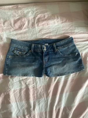 Lågmidjade blå jeansshorts - Säljer ett par riktigt snygga lågmidjade jeansshorts som är helt nya! Tog bort lappen men har inte använt dom. Storlek 40 så passar M/L. 