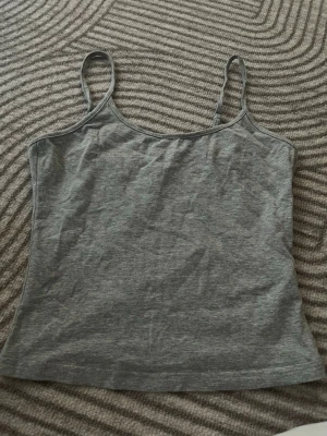 Grå linnetopp från SHEIN - En enkel och stilren grå linnetopp från SHEIN med tunna axelband. Perfekt att matcha med jeans eller kjol för en clean look. Tillverkad i mjuk bomull som känns skön mot huden.