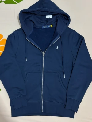 Polo Ralph Lauren  - Säljer en ny, oanvänt mörkblå polo tröja med dragkedja. Mjukt bomullsmaterial som är skönt att bära. Försten till kvarn! 