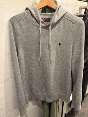 Ljusgrå hoodie med broderad detalj - Säljer en stilren ljusgrå hoodie. (Morris) köpt för 2500