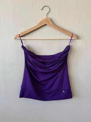 Phard Lila linnetopp med tunna axelband - Snygg lila linnetopp med tunna axelband och draperad front. Toppen har en enkel, stilren design och är perfekt för varma dagar. Materialet känns mjukt och följsamt mot huden.0211