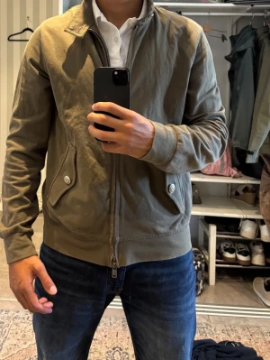 Olivgrön overshirt från Circolo 1901 - Snygg olivgrön overshirt från Circolo 1901 med dragkedja framtill, två fickor med knapp och ribbade muddar. Tröjan har en stilren ståkrage med knapp och är tillverkad i ett mjukt bomullsliknande material. Perfekt för dig som vill ha en clean och modern look.