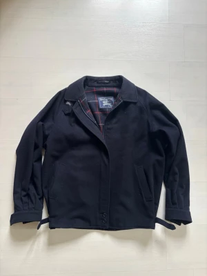 Ulljacka från Burberry - Säljer denna höst/vinterjacka från Burberry som både tjejer och killar kan ha. Den är i gott skick utan några större effekter samt tillverkad i 80% ull och 20% alpacka. Ulljackor utan någonsomhelst plast i är väldigt ovanligt nu för tiden och gör denna sällsynt. Hör av dig om du undrar något!