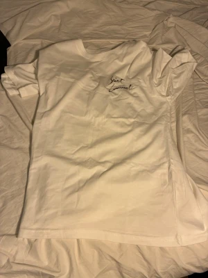 Vit tshirt med text  - En fet vit tshirt med text på bröstet och ryggen. Passar dig som är runt 170-175. Hör av er vid någon fundering. Pris går att diskutera. 