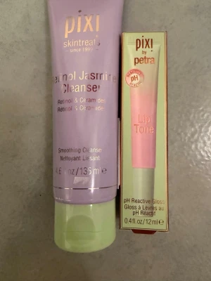 Pixi rengöring & läppglans duo - Säljer ett set från Pixi med en Retinol Jasmine Cleanser (135 ml) i lila tub med grön kork och ett Lip Tone pH Reactive Gloss (12 ml) i rosa tub med grön botten. Perfekt för dig som vill ha både rengöring och gloss i snygga förpackningar.