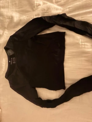 Svart långärmad träningströja H&M Move - Säljer en svart långärmad träningströja från H&M Move i storlek XS. Tröjan har rund halsringning och är tillverkad i ett stretchigt, mjukt material som passar perfekt för träning eller sportaktiviteter.