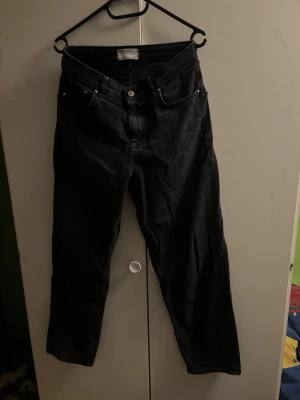 Svarta raka jeans - Säljer ett par svarta jeans med rak passform och klassisk femficksdesign. Jeansen har normal midja och är tillverkade i ett slitstarkt denimtyg. Perfekta för dig som gillar en enkel och stilren look.