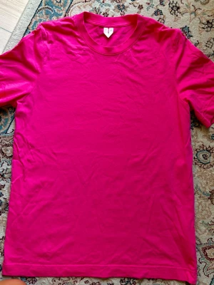 Rosa t-shirt - En otrolig fin rosa t-shirt, som kommer att lysa upp dig en varm sommar dag. Perfekt med ett par fina jeans eller en kjol. 