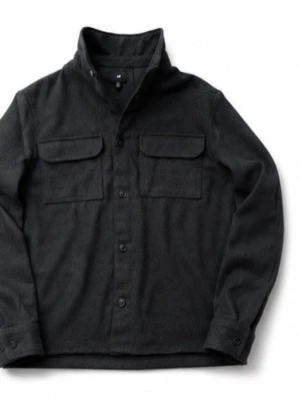 Mörkgrå overshirt från H&M - Stilren mörkgrå overshirt från H&M i mjukt material. Skjortjackan har två stora bröstfickor med lock, knäppning framtill och klassisk krage. Perfekt lager-på-lager-plagg för en avslappnad look.