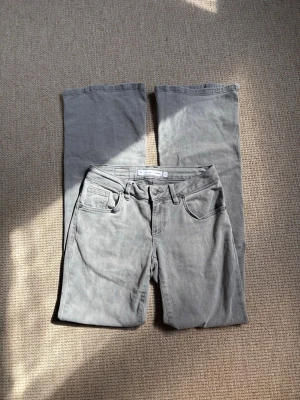 Subdued jeans - Ljusgrå, lågmidjade, utsvängda jeans från Subdued. Fint skick, endast använt 2 gånger! Midjemått rakt över: ca 37 cm (dock stretchiga)