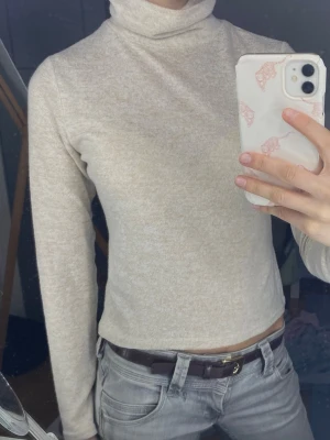 Beige polotopp  - Mysig beige polotopp med lång ärm och croppad passform. Tillverkad i väldigt  lent / mjukt material. Perfekt tröja till vardagen. 🤩