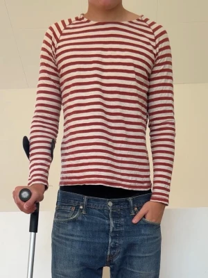 Nudie Jeans Tröja röd - Röd långärmad T-shirt ifrån Nudie jeans i strl Xs men passar även S! Bra skick utan nåra defekter och hör gärna av er vid frågor elr funderingar!!