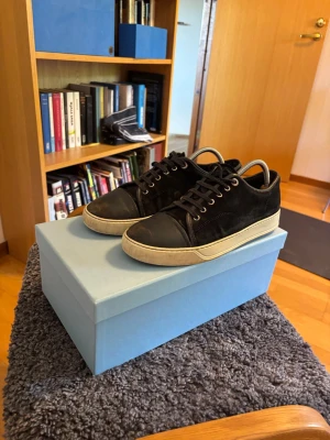 Lanvin sneakers strlk 42 i navy blue - Snygga navy sneakers i mocka från Lanvin med vita sulor. Klassisk låg modell med rund tå och diskreta sömmar. Perfekta för en stilren och avslappnad look.
