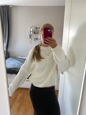 Vit oversized stickad tröja - Säljer en vit, oversized stickad tröja med grov ribbstickning och rund hals. Tröjan har långa ärmar och avslappnad passform, perfekt för lager på lager och en chill look. Materialet ser ut att vara mjukt och bekvämt, troligen bomull eller akryl.